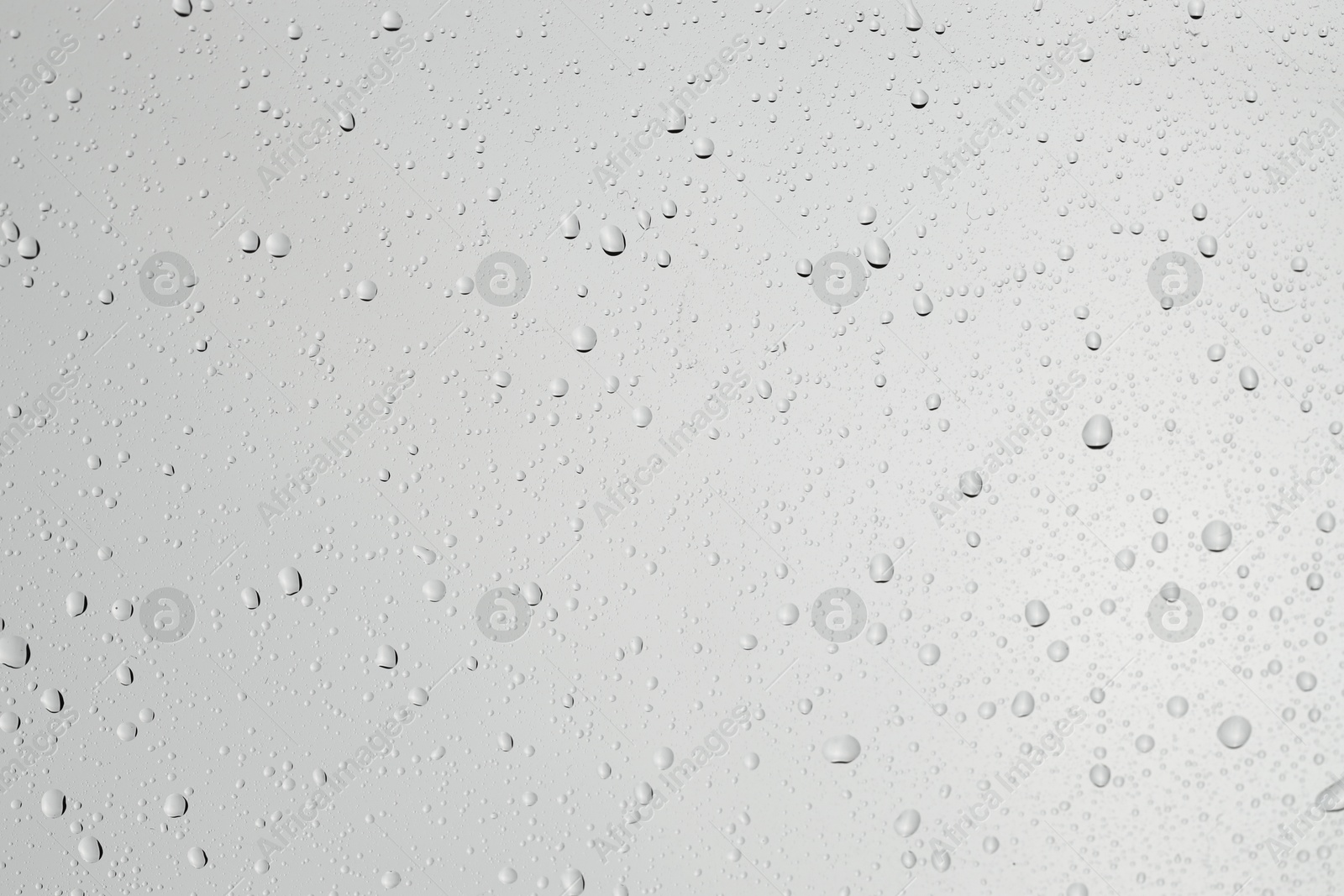 Photo of Water drops on light grey glass surface, top view