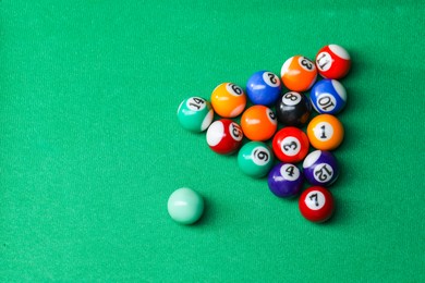 Photo of Billiard balls in triangle on green table, top view. Space for text