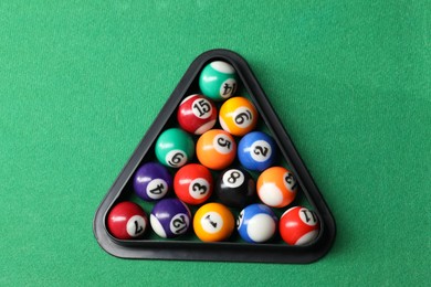 Photo of Billiard balls triangle rack on green table, top view