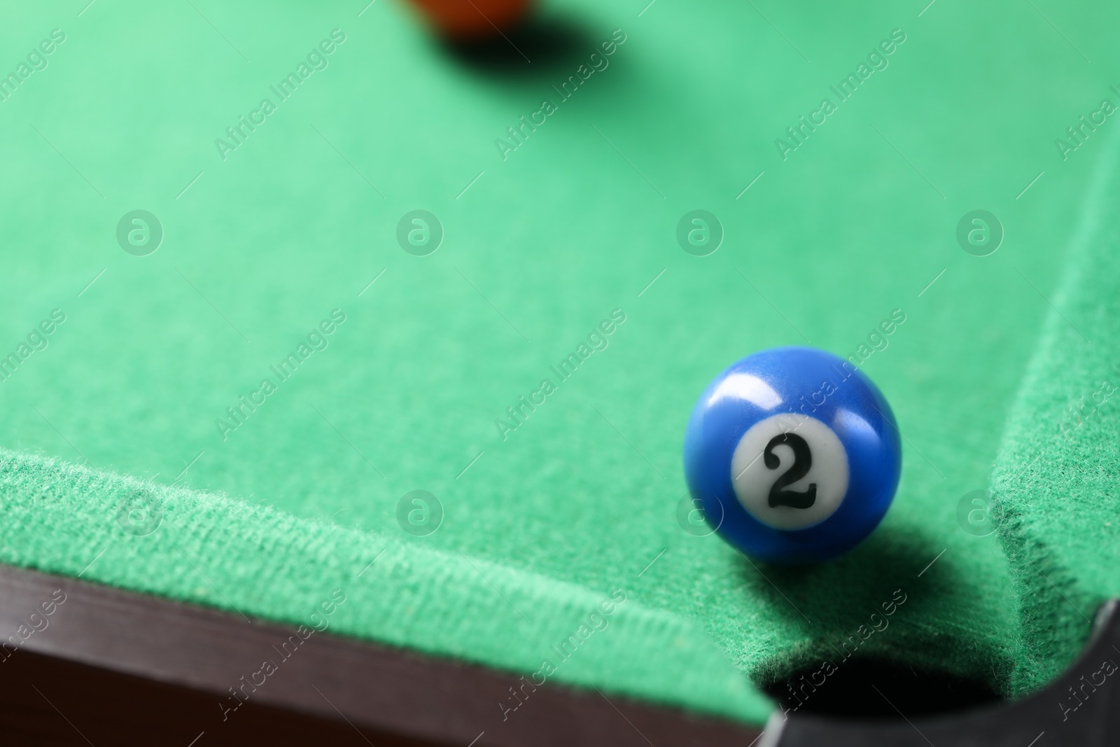 Photo of Billiard ball on green table, closeup. Space for text