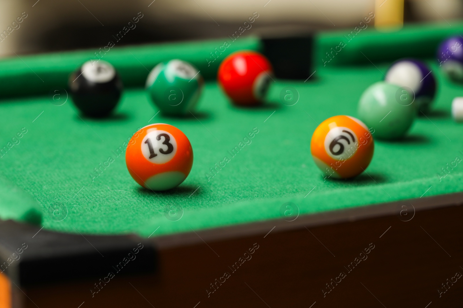 Photo of Many colorful billiard balls on green table indoors, closeup