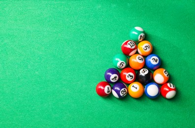 Photo of Billiard balls in triangle on green table, top view. Space for text