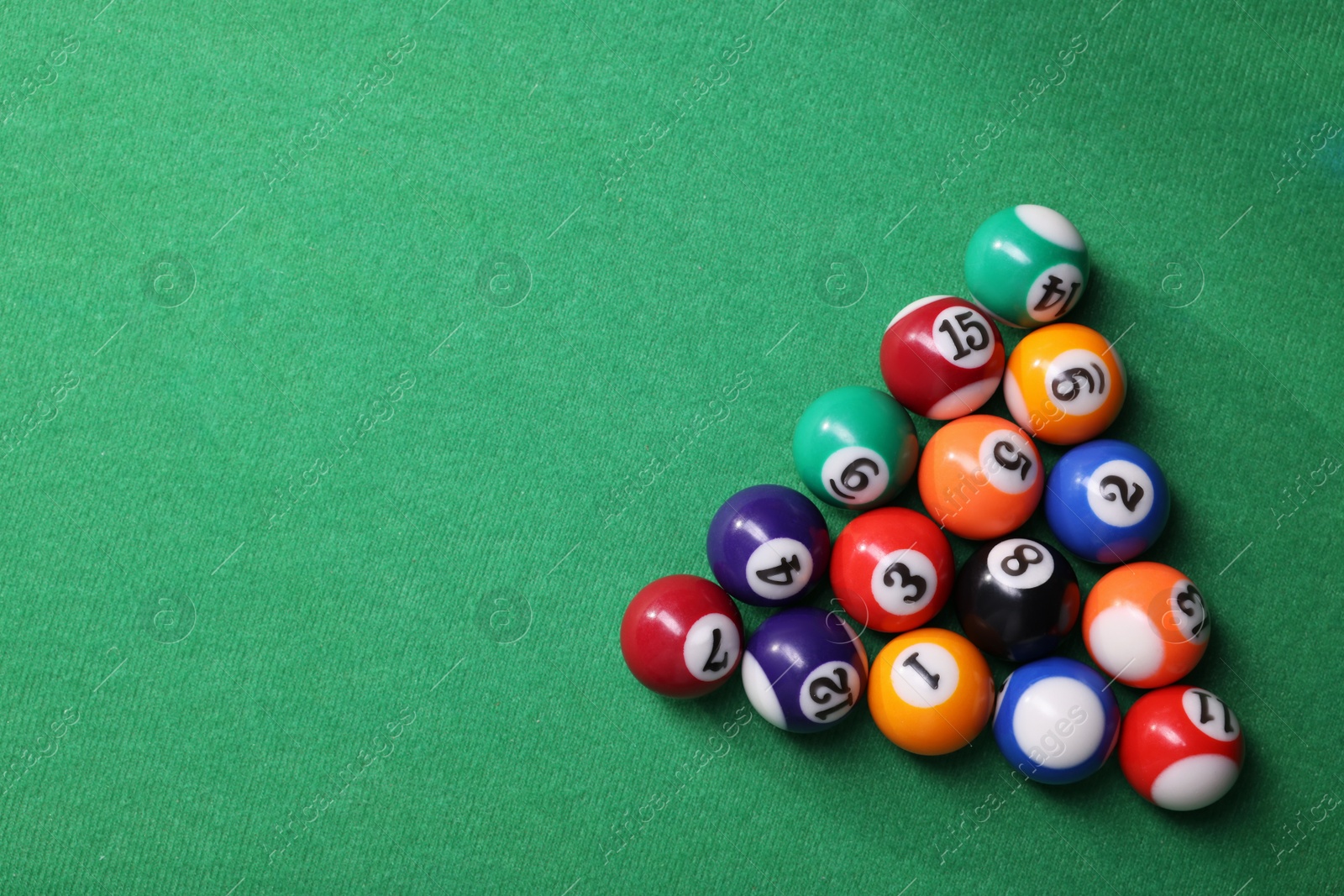 Photo of Billiard balls in triangle on green table, top view. Space for text