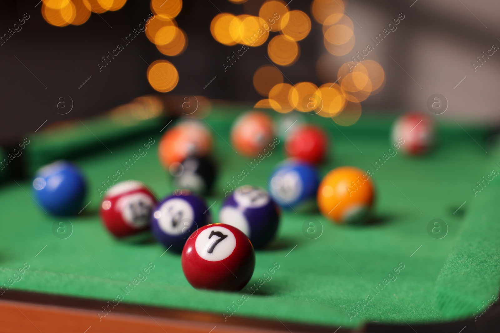 Photo of Many colorful billiard balls on green table indoors, closeup