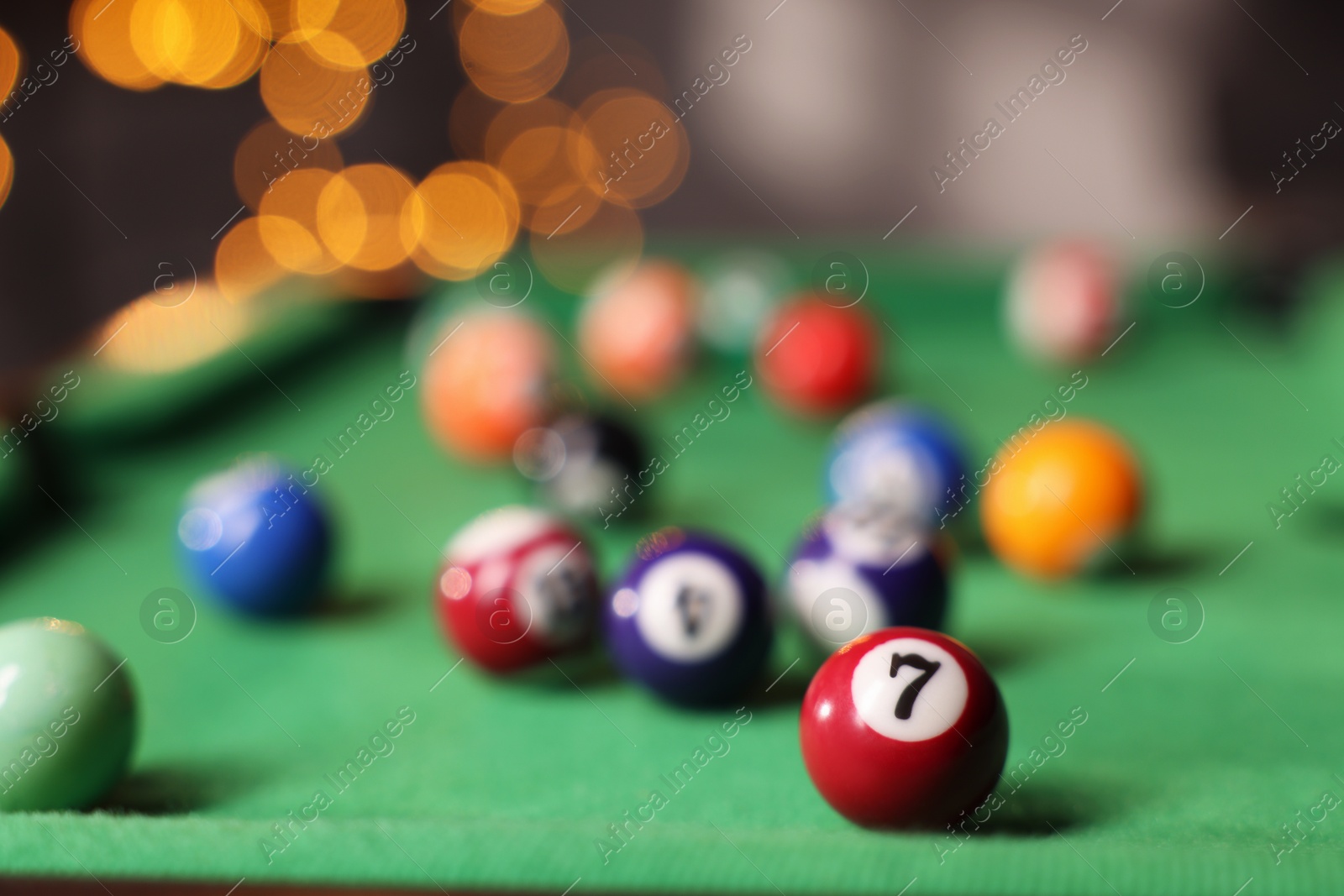 Photo of Many colorful billiard balls on green table indoors, closeup