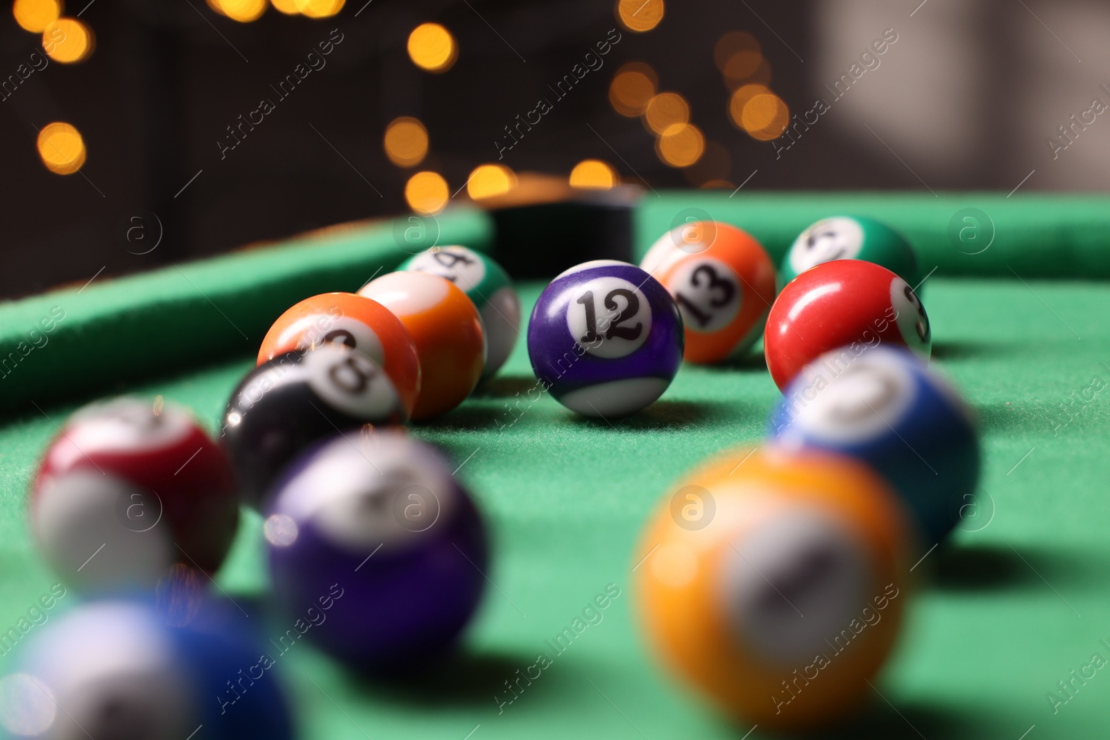 Photo of Many colorful billiard balls on green table indoors, closeup