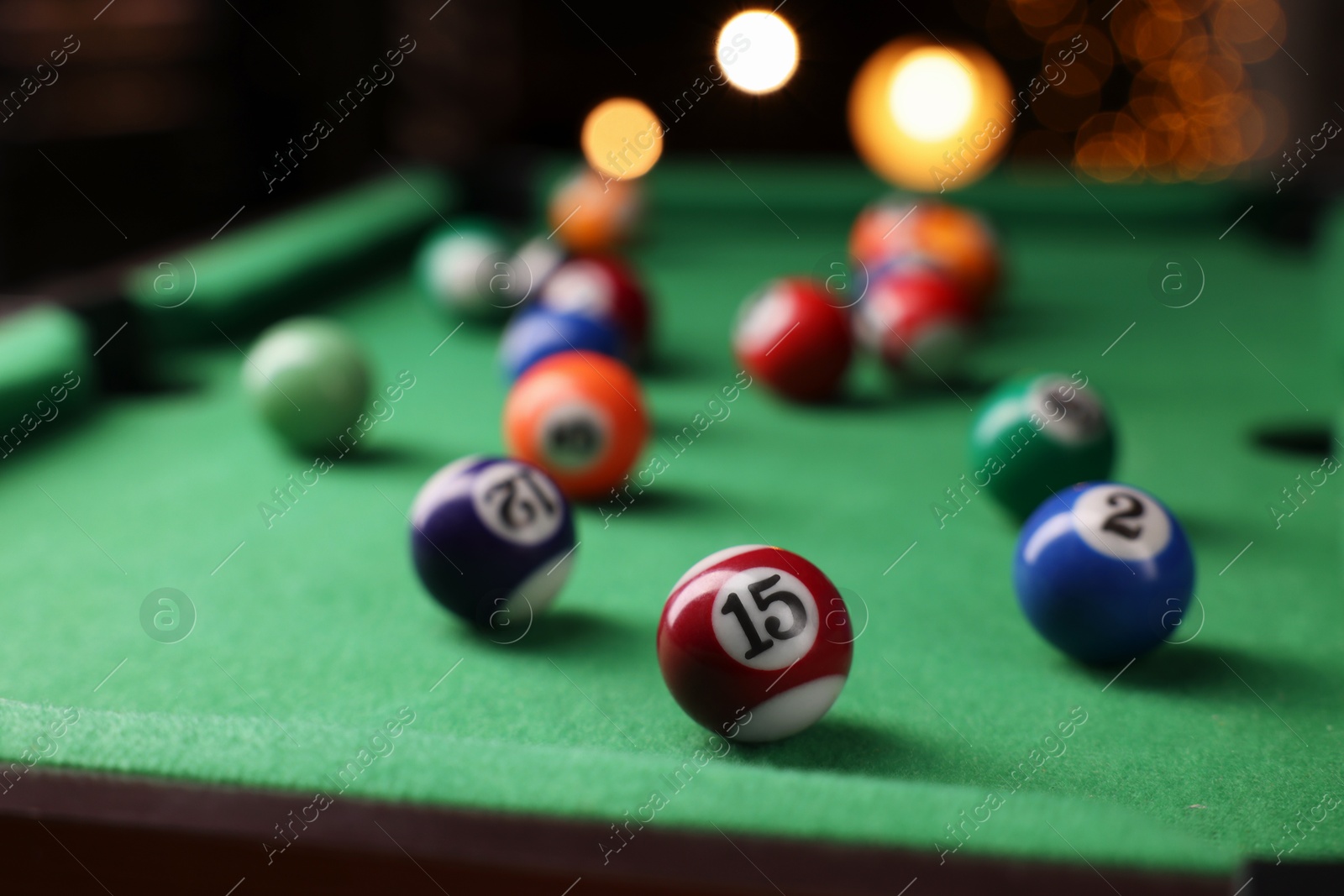 Photo of Many colorful billiard balls on green table indoors, closeup