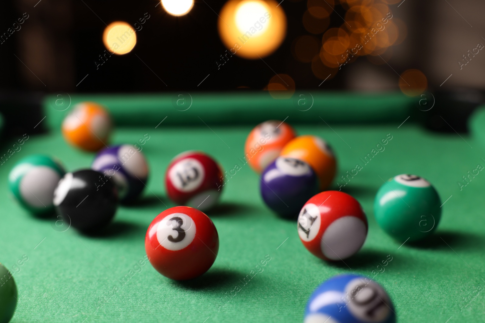 Photo of Many colorful billiard balls on green table indoors, closeup