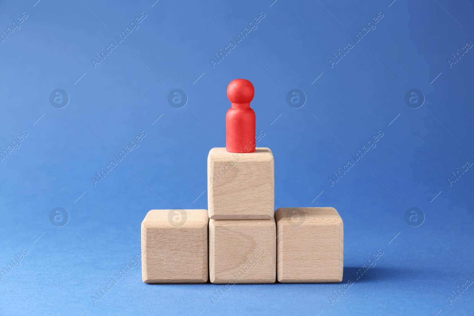 Photo of Competition concept. Human figure on wooden cubes against blue background