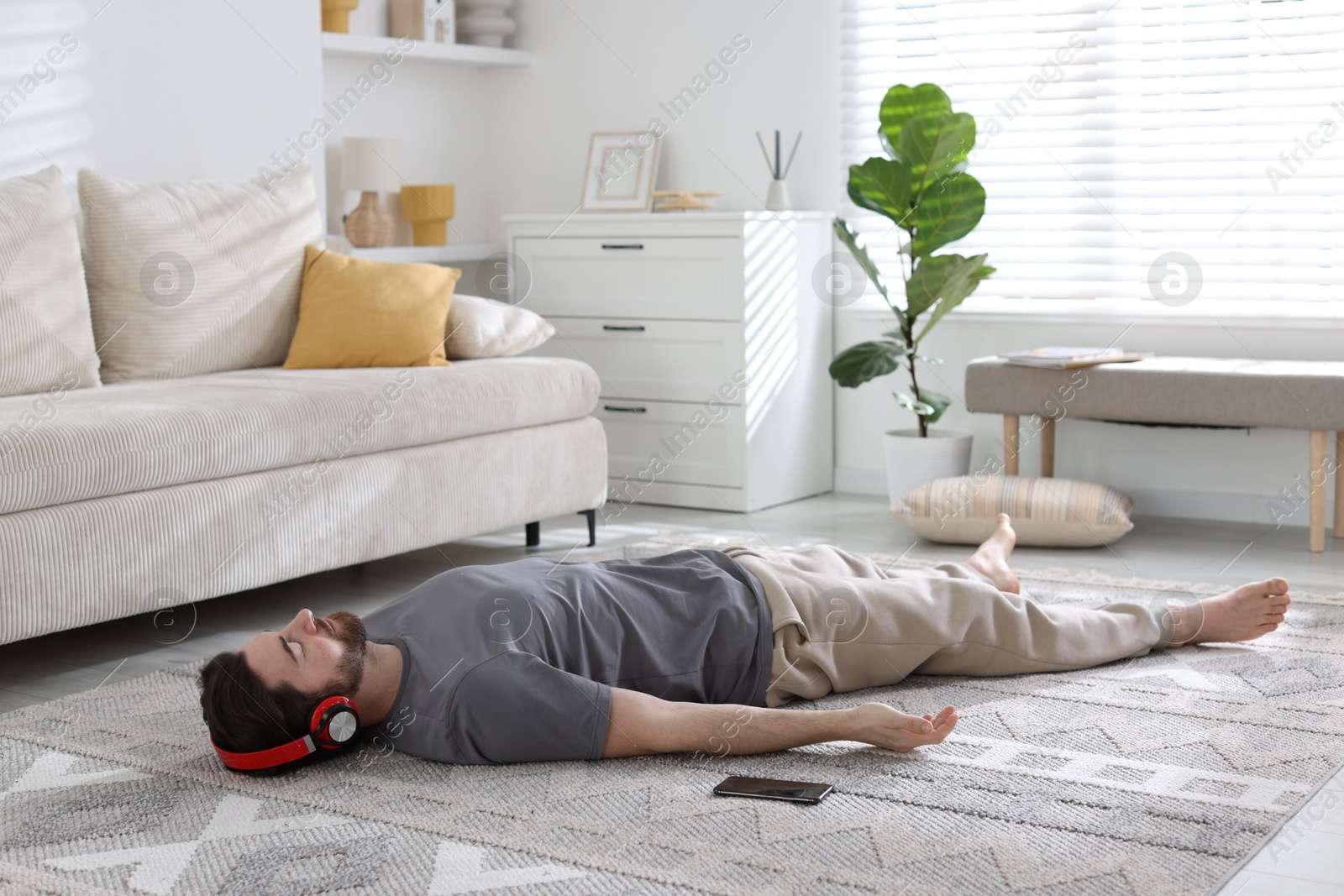 Photo of Man in headphones meditating on floor at home