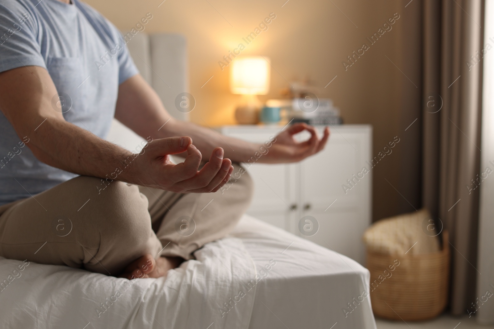 Photo of Man meditating on bed at home, closeup. Space for text