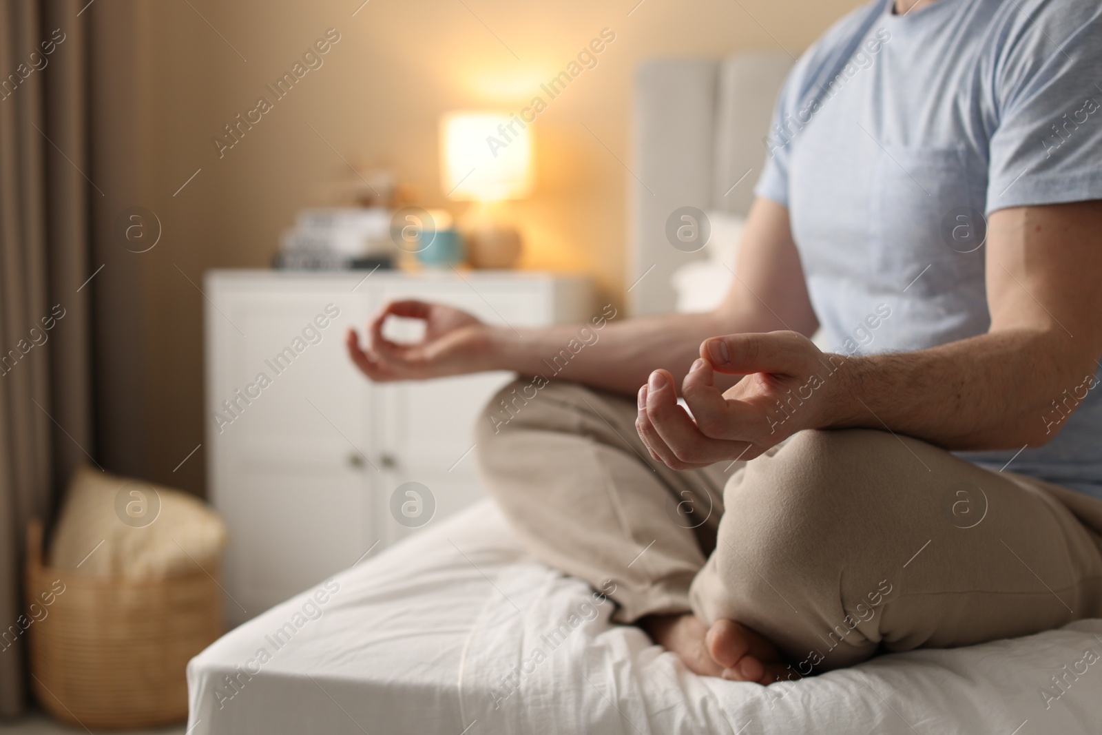 Photo of Man meditating on bed at home, closeup. Space for text