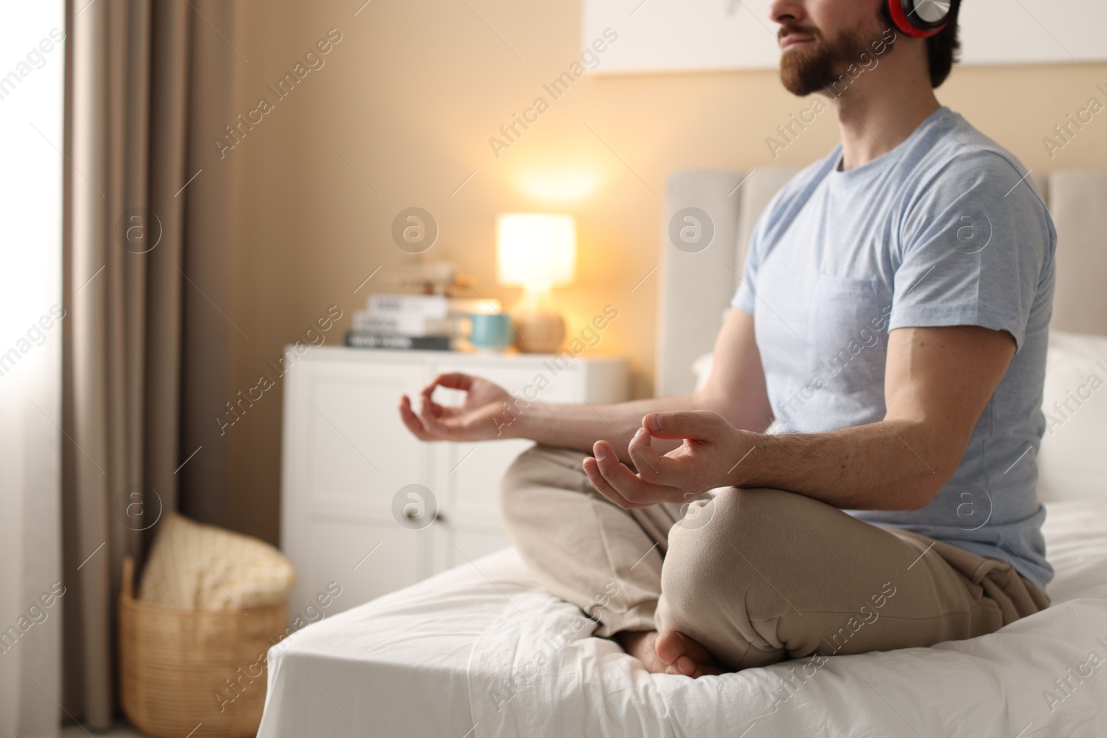 Photo of Man meditating on bed at home, closeup. Space for text