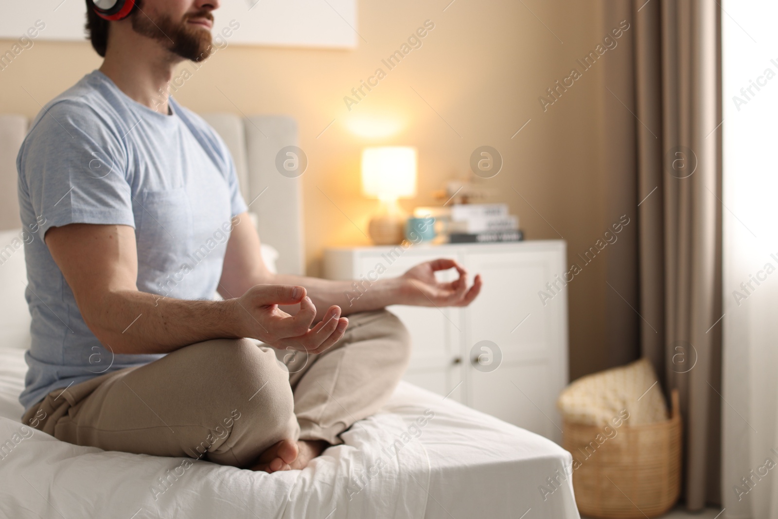 Photo of Man meditating on bed at home, closeup. Space for text