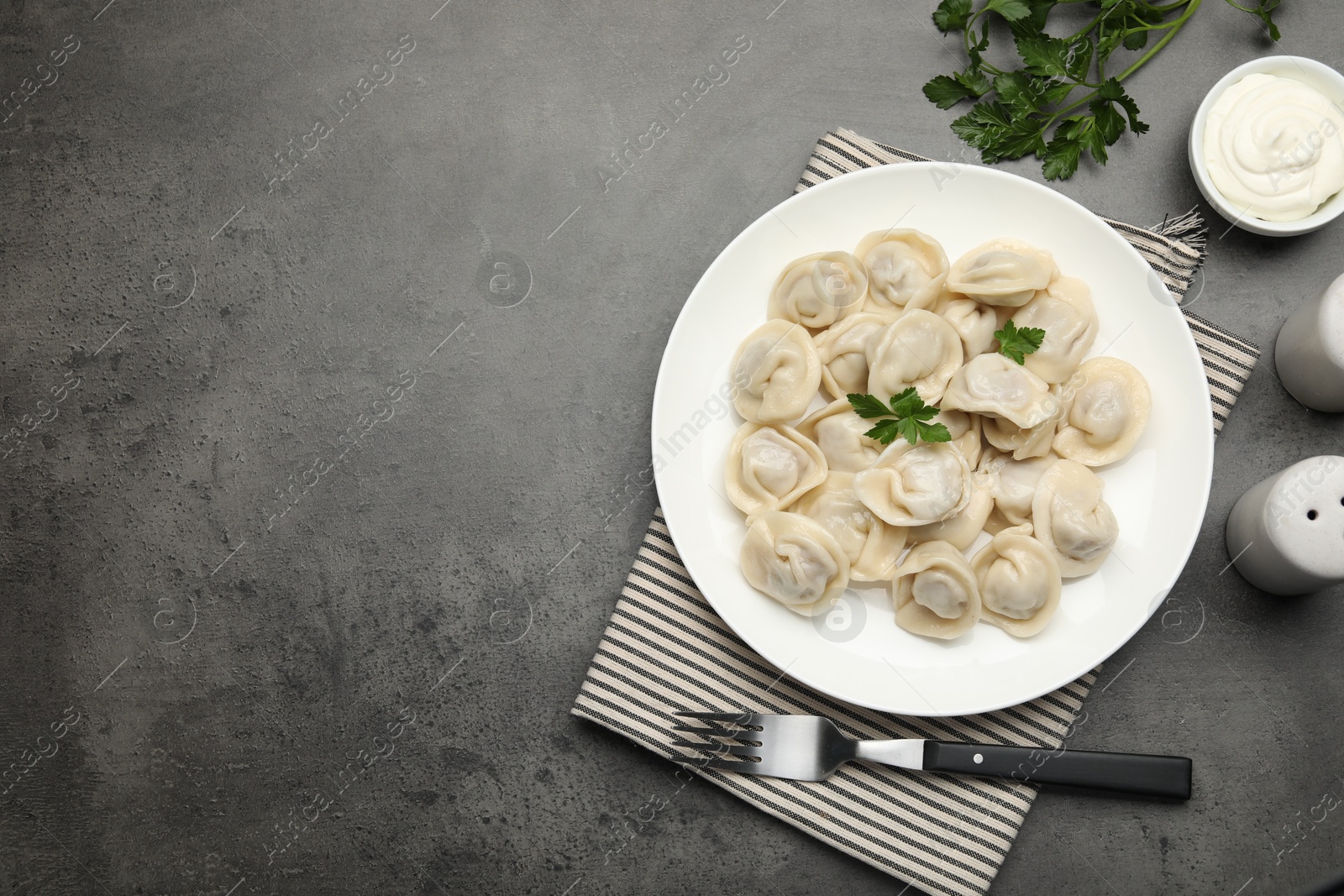 Photo of Delicious dumplings served on grey table, flat lay. Space for text