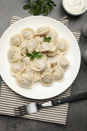 Photo of Delicious dumplings served on grey table, flat lay