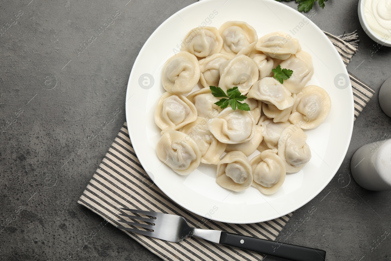 Photo of Delicious dumplings served on grey table, flat lay