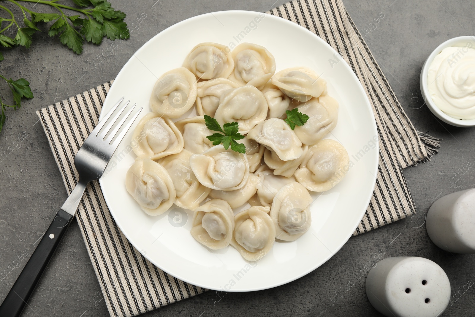 Photo of Delicious dumplings served on grey table, flat lay