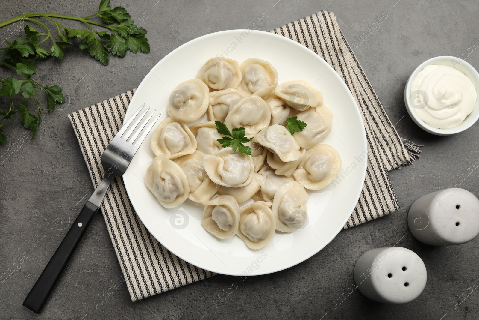 Photo of Delicious dumplings served on grey table, flat lay