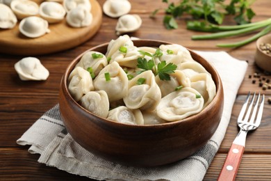 Photo of Delicious dumplings served on wooden table, closeup