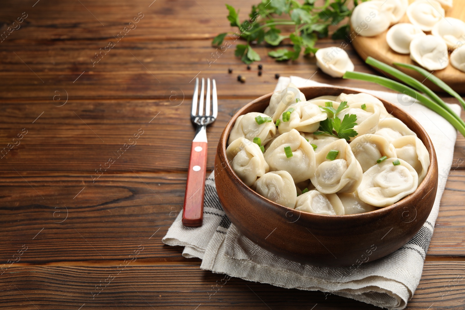 Photo of Delicious dumplings served on wooden table, space for text