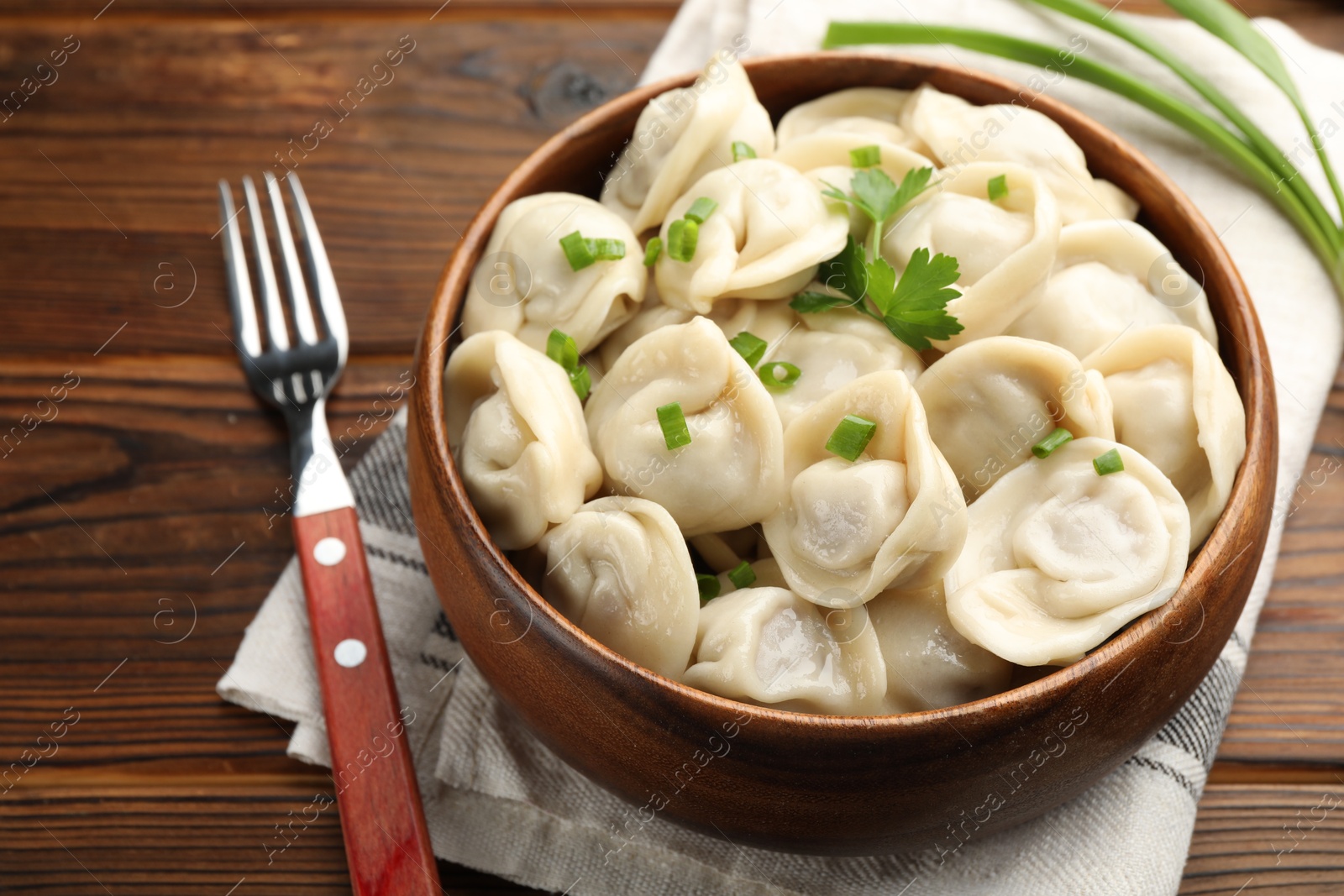 Photo of Delicious dumplings served on wooden table, closeup