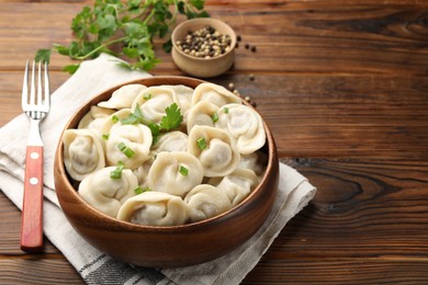 Photo of Delicious dumplings served on wooden table, space for text