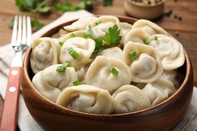 Photo of Delicious dumplings with fresh green onion and parsley served on table, closeup