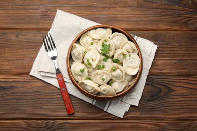 Photo of Delicious dumplings served on wooden table, flat lay