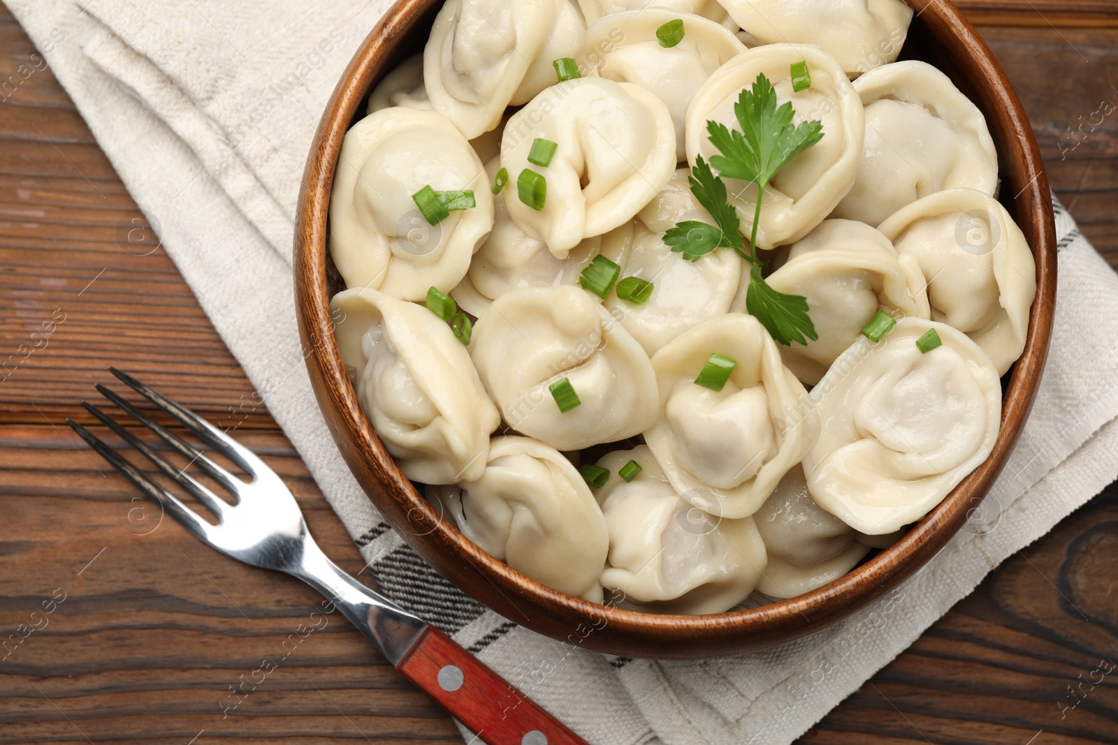 Photo of Delicious dumplings served on wooden table, flat lay