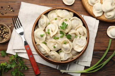 Photo of Delicious dumplings served on wooden table, flat lay