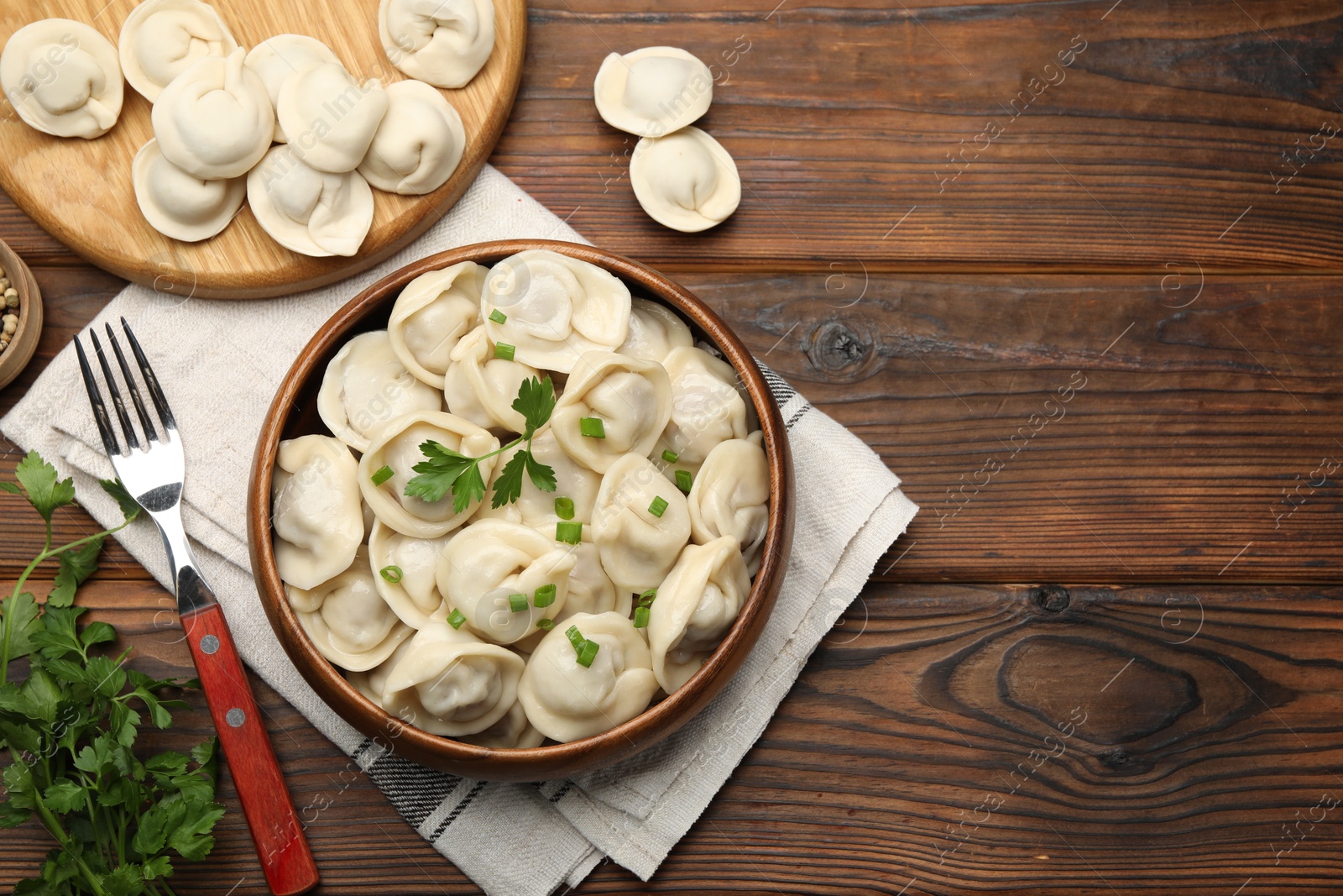 Photo of Delicious dumplings served on wooden table, flat lay. Space for text