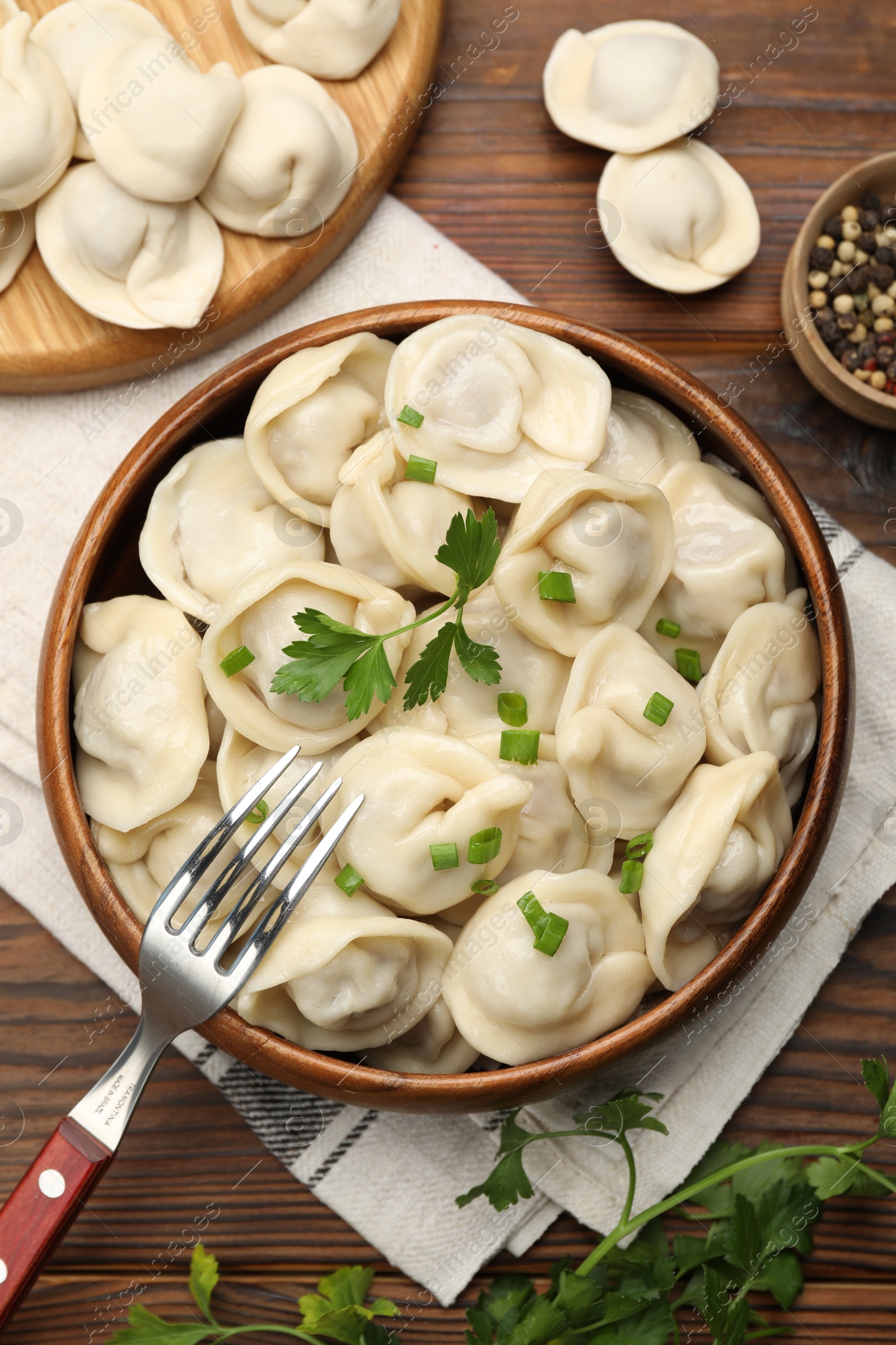 Photo of Delicious dumplings served on wooden table, flat lay