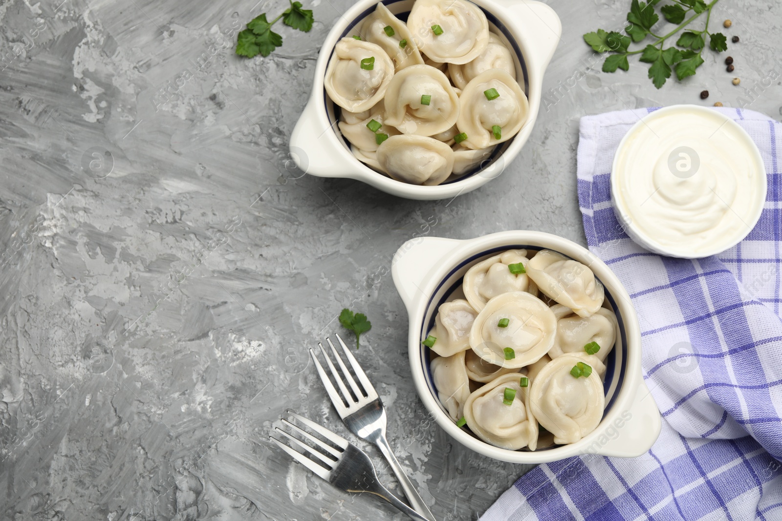 Photo of Delicious dumplings served on grey table, flat lay. Space for text