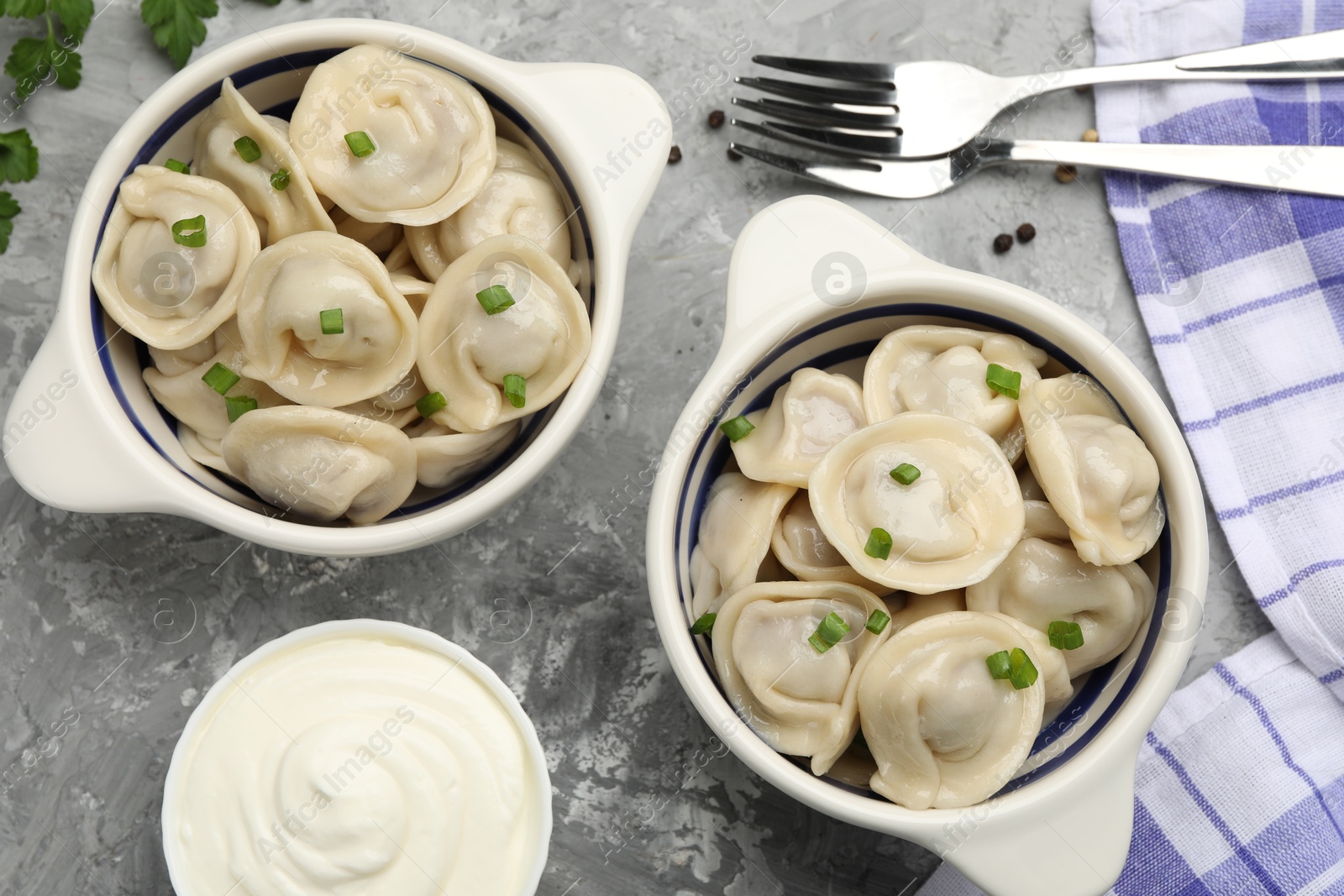 Photo of Delicious dumplings served on grey table, flat lay