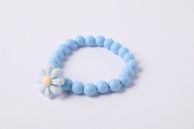 Photo of One blue hair tie with flower on white background