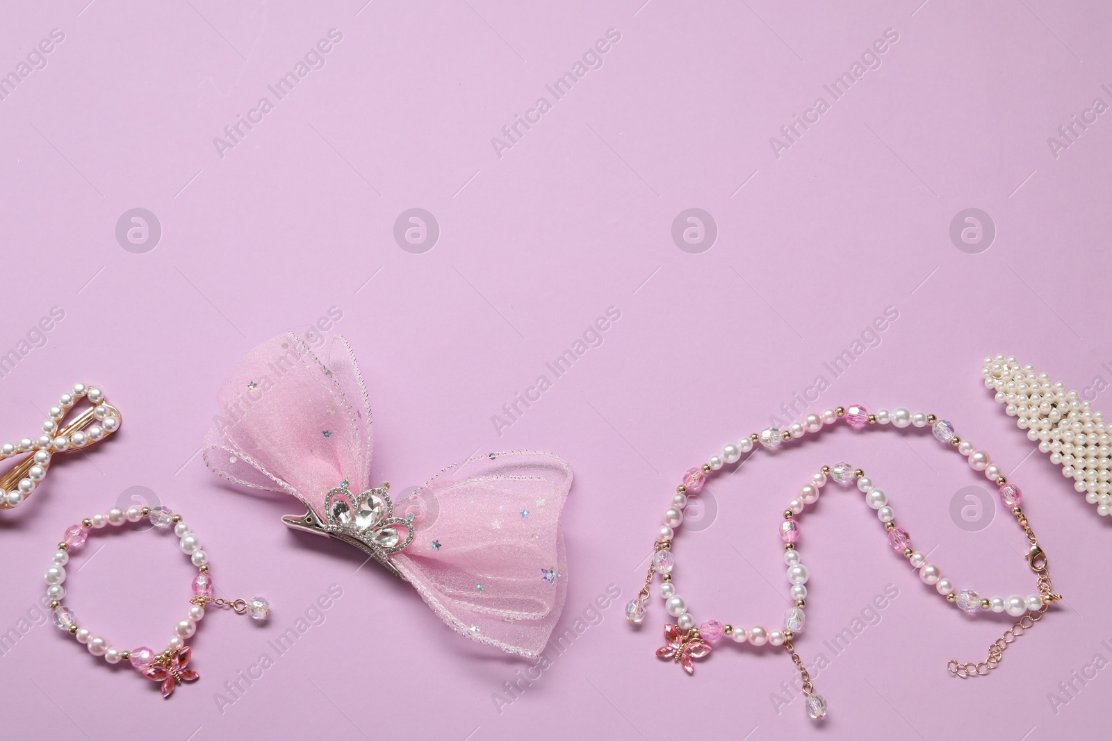 Photo of Cute hair accessories on lilac background, flat lay. Space for text