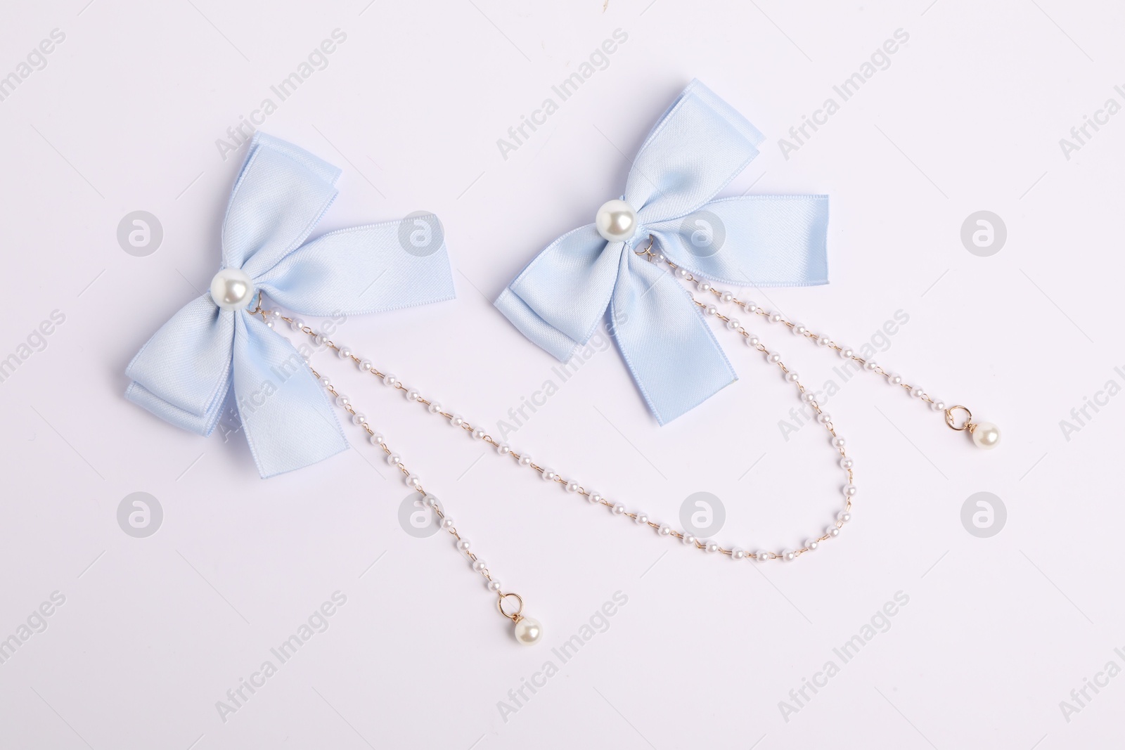 Photo of Beautiful hair bows with beads on white background, top view