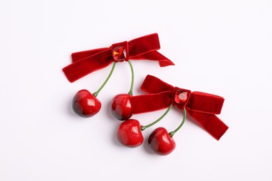 Photo of Beautiful hair bows with cherries on white background, top view