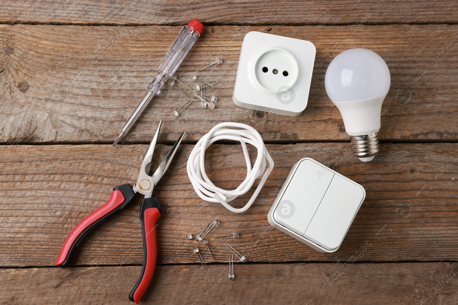 Photo of Different electrical tools on wooden table, flat lay