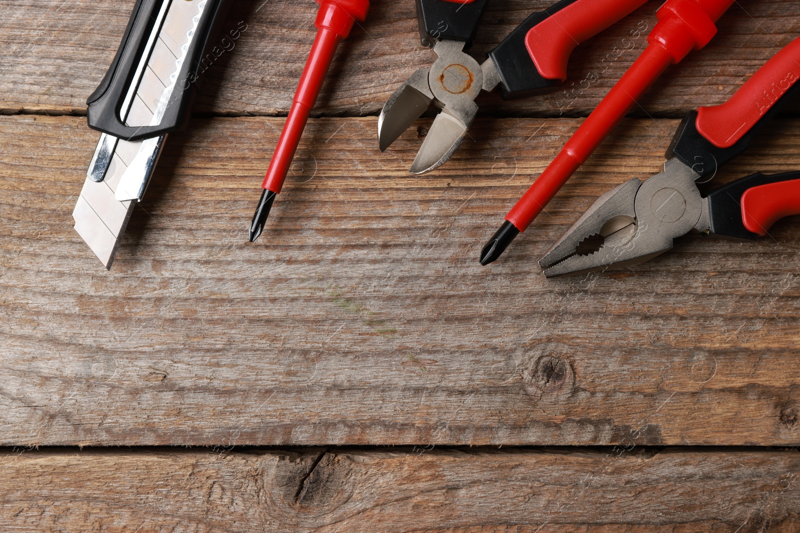 Photo of Different electrical tools on wooden table, flat lay. Space for text