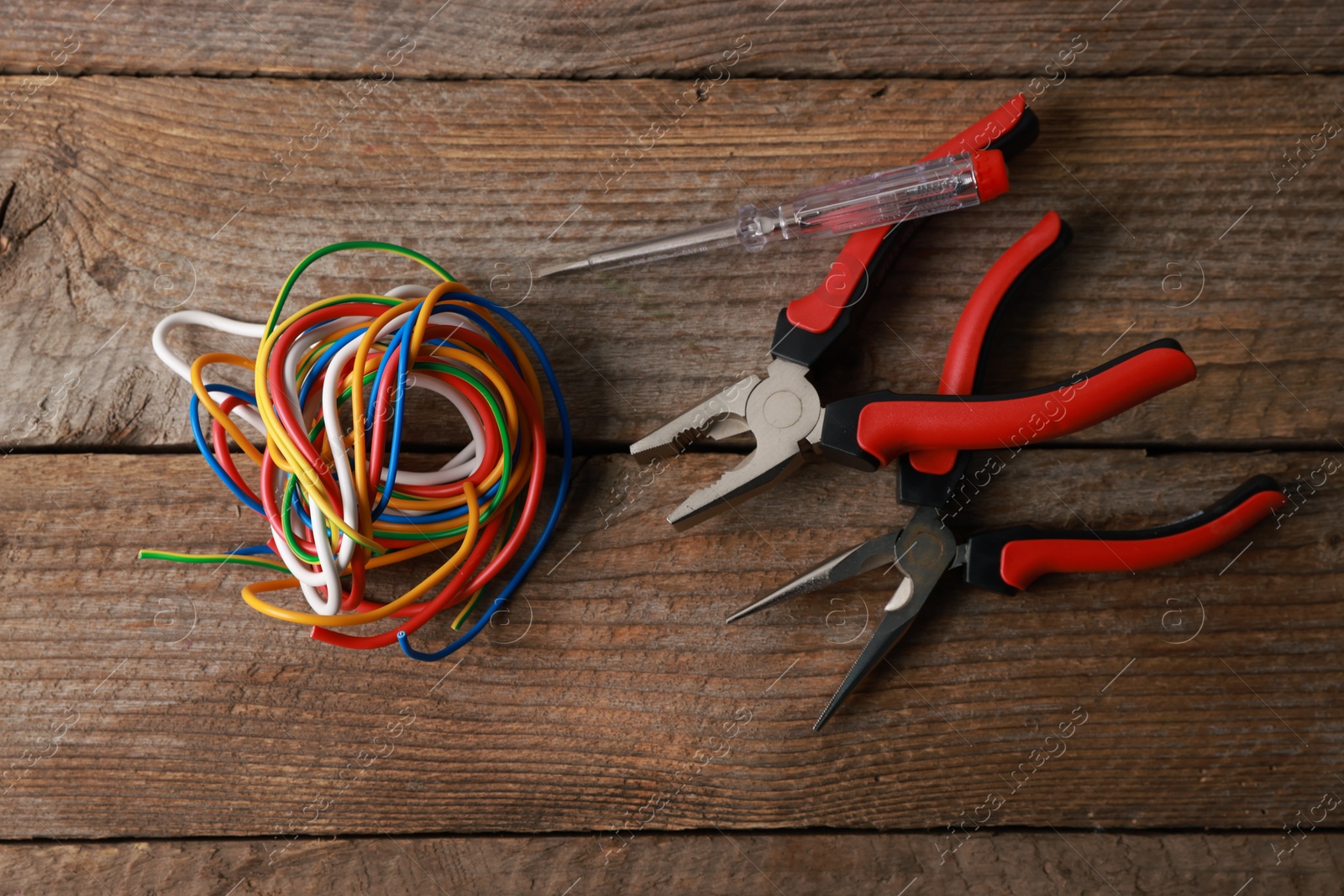 Photo of Different electrical tools on wooden table, flat lay