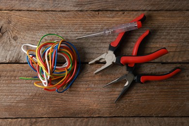 Photo of Different electrical tools on wooden table, flat lay