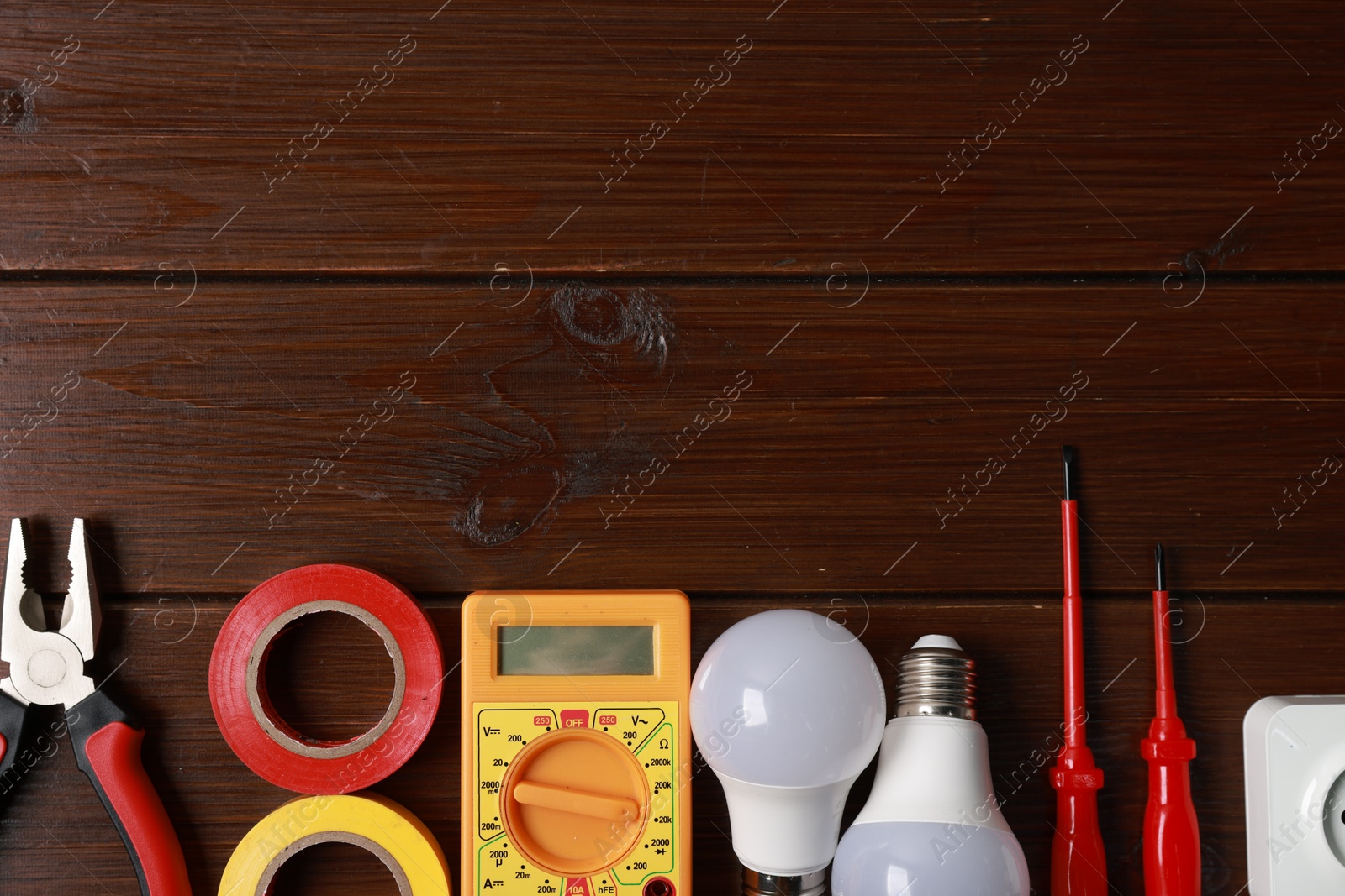 Photo of Different electrical tools on wooden table, flat lay. Space for text