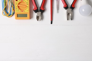 Photo of Different electrical tools on white wooden table, flat lay. Space for text