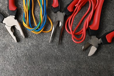 Photo of Different electrical tools on grey table, flat lay. Space for text