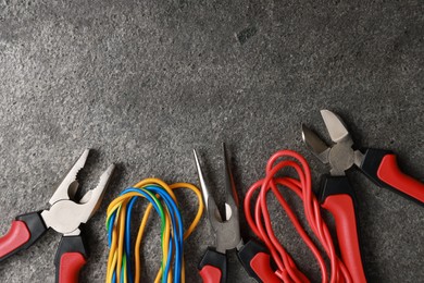 Photo of Different electrical tools on grey table, flat lay. Space for text