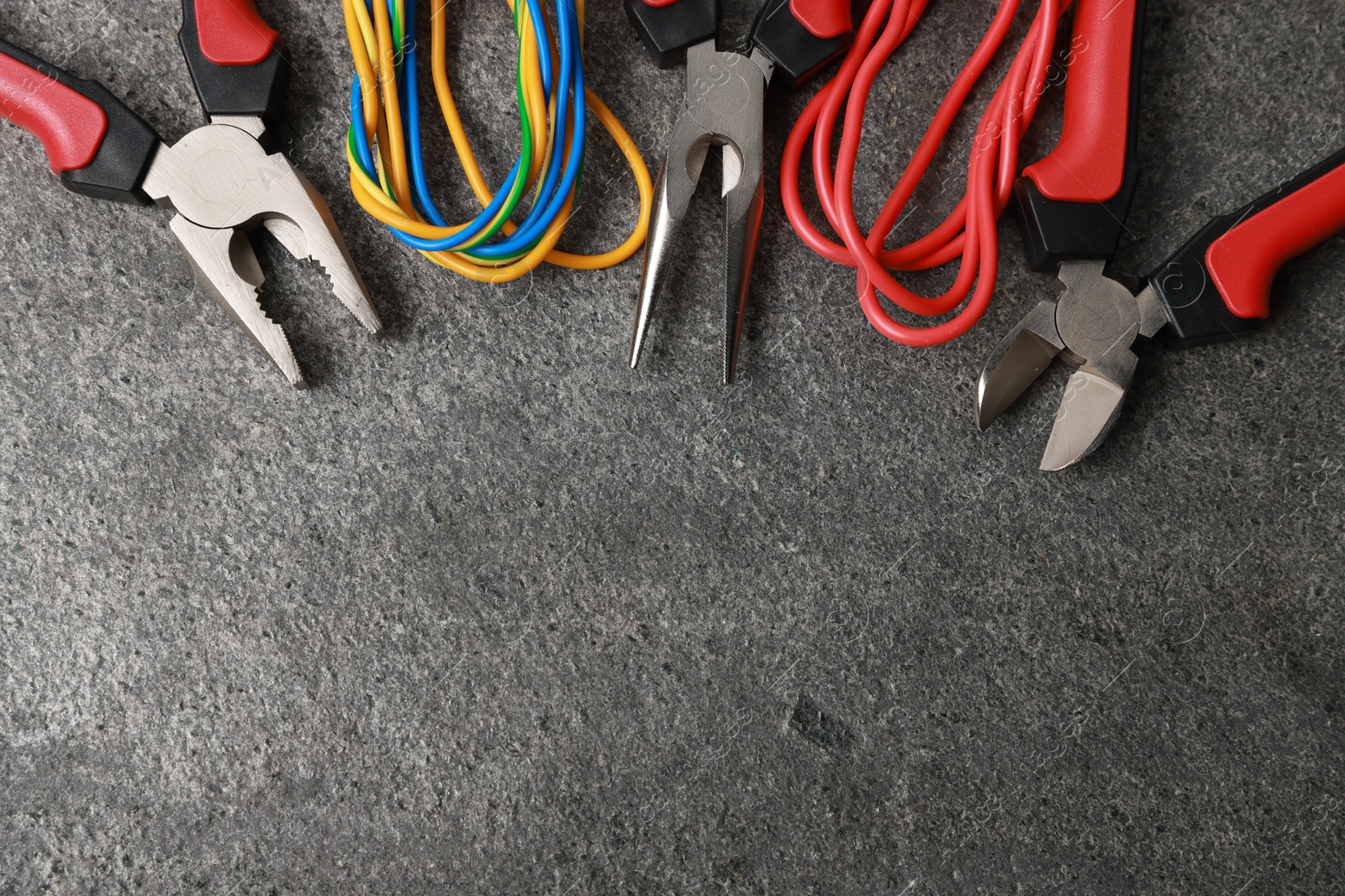 Photo of Different electrical tools on grey table, flat lay. Space for text