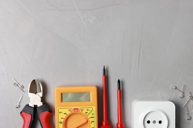 Photo of Different electrical tools on grey table, flat lay. Space for text