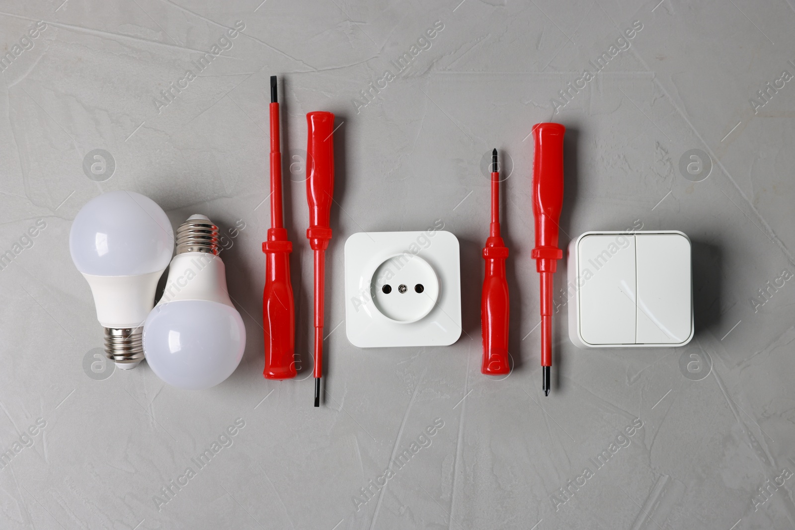 Photo of Different electrical tools on grey table, flat lay